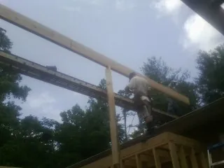 Carpenter setting a ridge beam over a new addition frame — Ice Dam Removal by Roofing Brothers in Trevorton