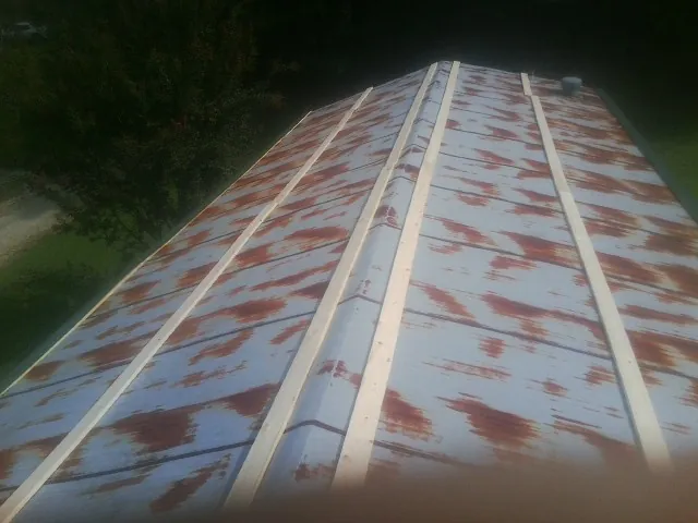 Rusted metal roof panels with new wood purlins before replacement — Storm Damage Roof Repair in Trevorton by Roofing Brothers