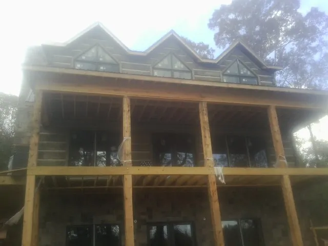 Dormers and porch framing on a large log home under construction — Roof Coating work by our crew in Trevorton