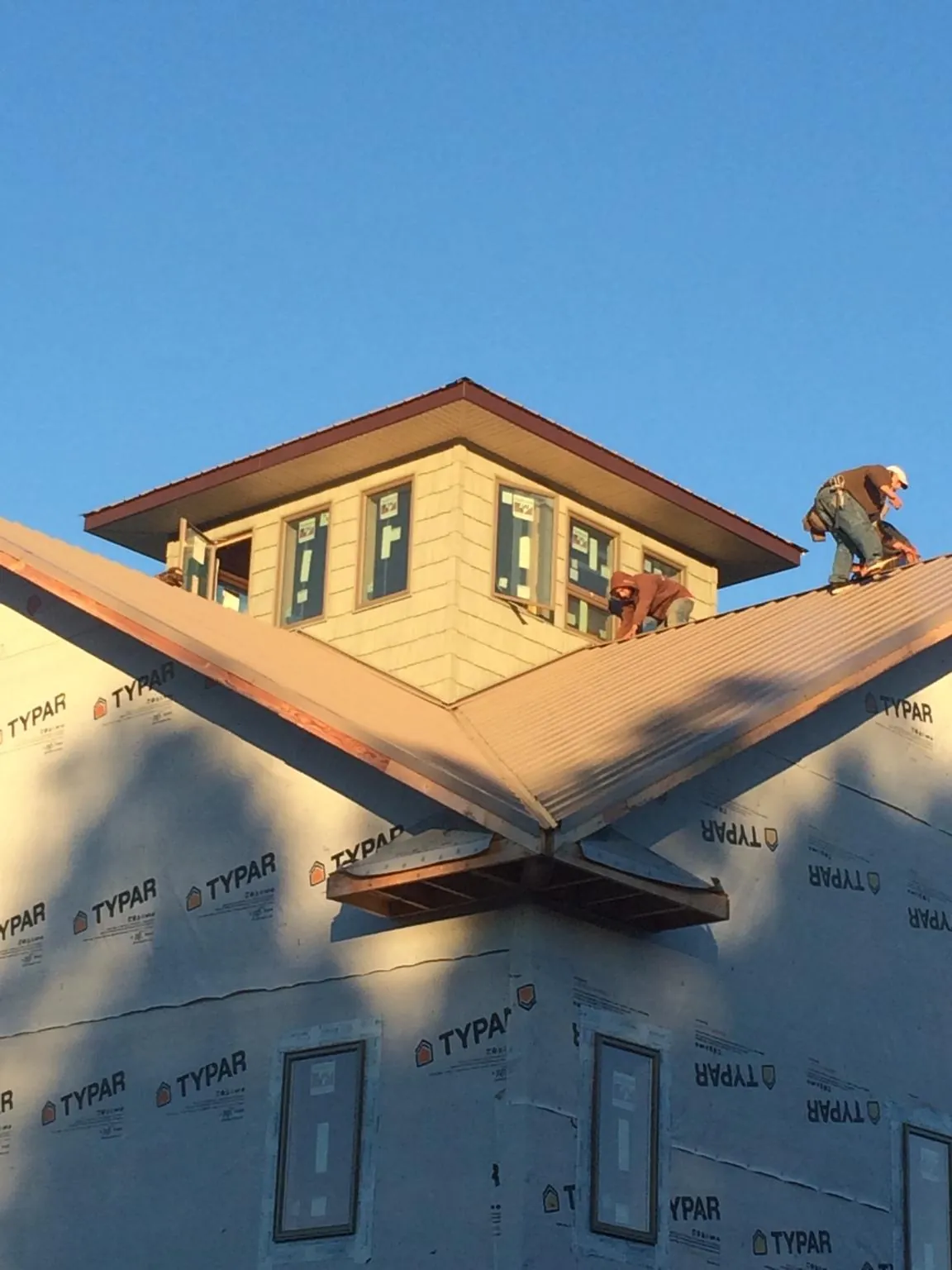 Roofers working around a rooftop cupola on a new metal roof at sunset — Roof Waterproofing in Trevorton by Roofing Brothers